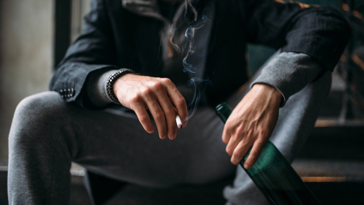 Young man smoking cigarette sitting down.